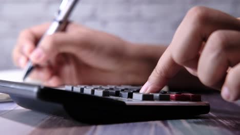 person calculating with calculator and pen