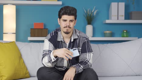 Stressed-young-man-waving-his-phone,-occasionally-looking-at-the-phone.