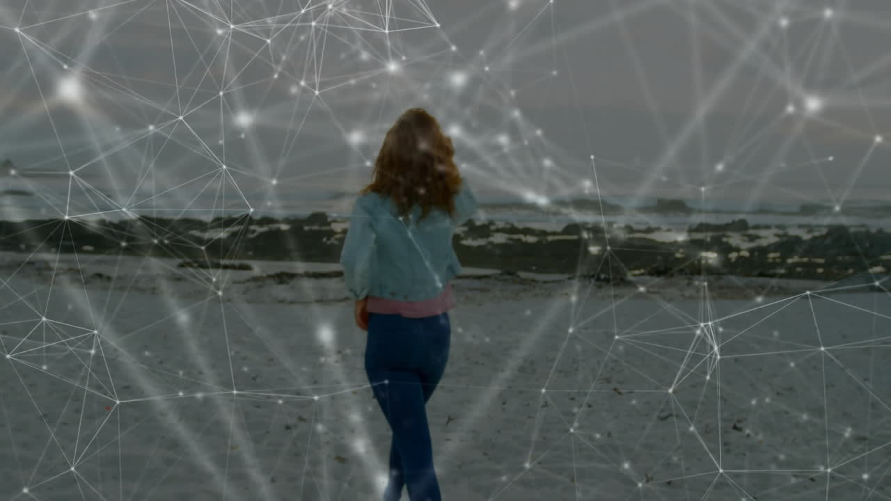 Walking on beach, woman exploring digital network connections in animation overlay