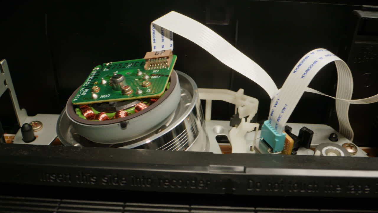 Old video recorder inside close-up, VHS. Retro player in neon blue light, vintage video cassette broadcasting, audio tape.