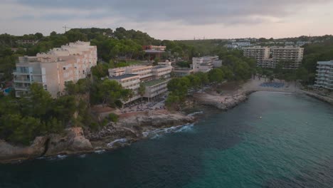 Aerial---coastal-multistory-beach-front-hotels-near-turquoise-bay,-Mallorca