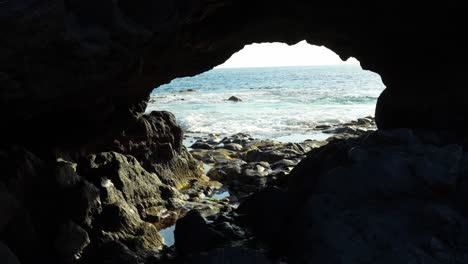 ocean waves flowing towards cave, view from inside