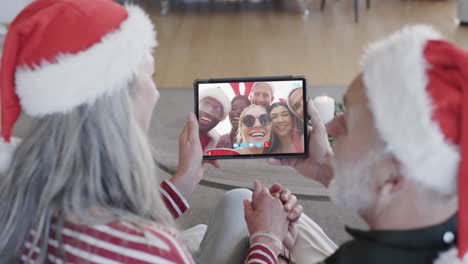 feliz pareja de mayores y amigos teniendo navidad tableta llamada de video, cámara lenta