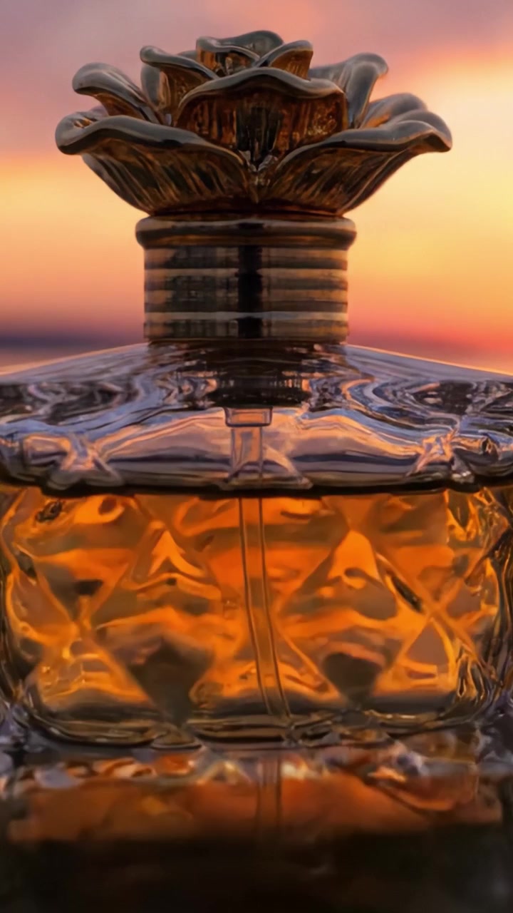Elegante flacone di profumo che riflette i colori del tramonto, mostrando un intricato design floreale e un'accattivante essenza dorata in un'ambientazione esterna mozzafiato