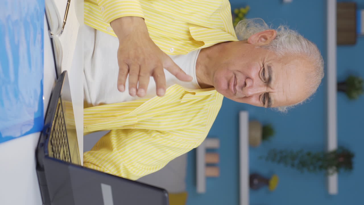 Vertical video of Home office worker old man is disgusted.