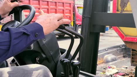 close-up shot of forklift male operator hands on the levers control