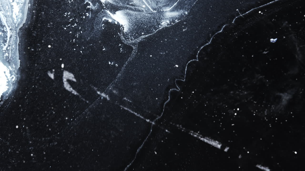 Ink mixing, macro shot showing swirling dark ink, creating artistic textures on a surface