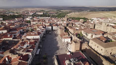 Toma-Aérea-En-órbita-Sobre-La-Plaza-Mayor-Y-La-Torre-Bujaco-En-Cáceres,-España.