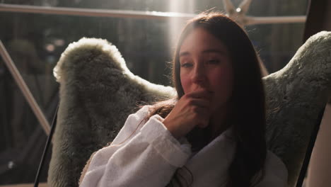 woman sitting in a comfy chair looking out the window