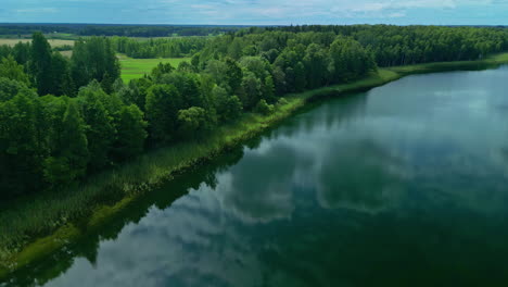 stormy clouds reflecting on calm lake water, aerial drone view