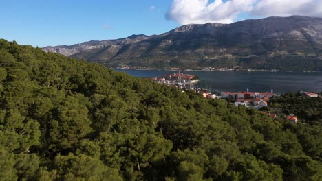 Vista-De-La-Ciudad-Histórica-De-Korcula-En-Un-Hermoso-Día-Soleado-Con-Cielo-Azul-Y-Nubes-En-Verano,-Isla-De-Korcula,-Dalmacia,-Croacia---Toma-Aérea-De-Drones