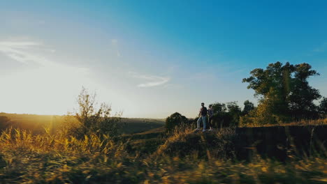 couple enjoying a walk through grass land. young woman walking with her boyfriend on grass field