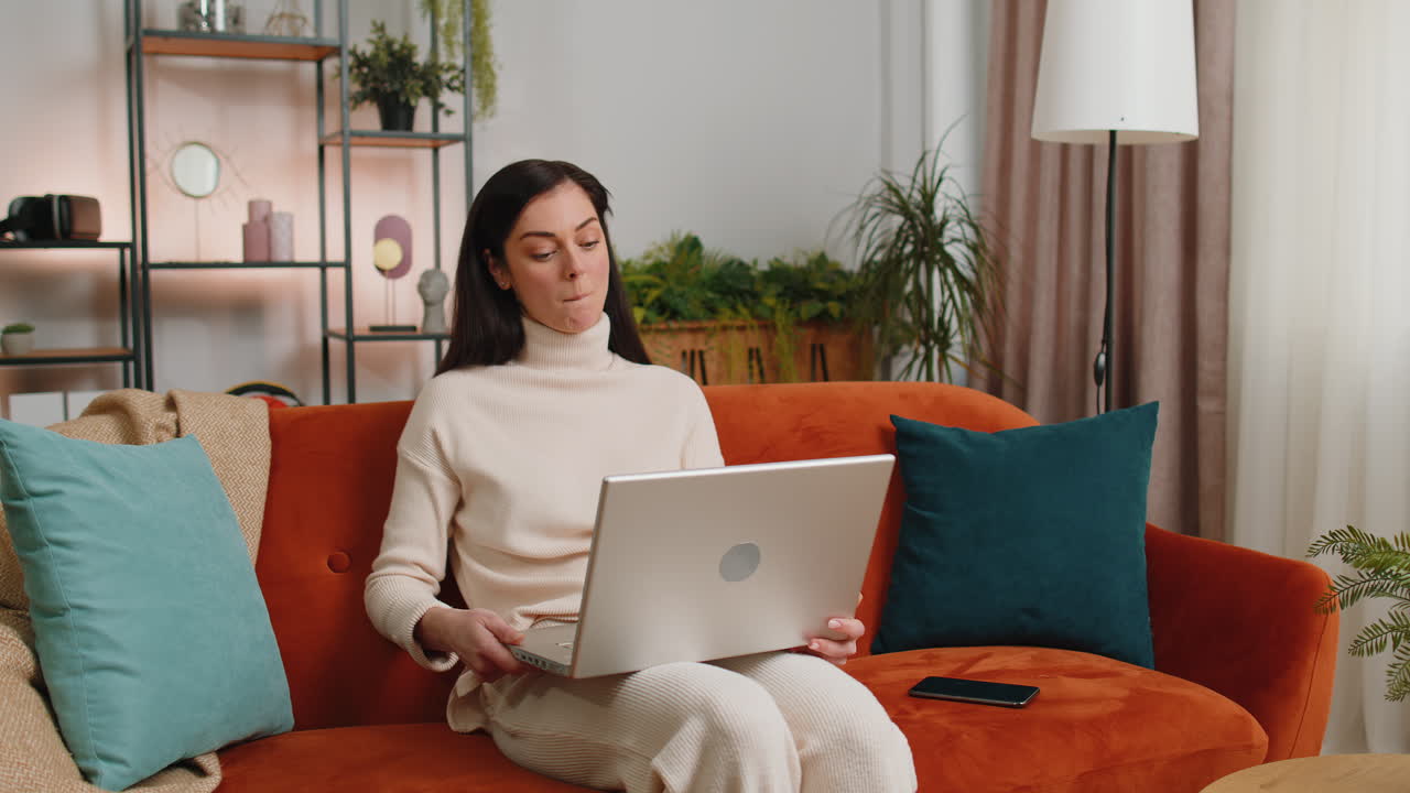 Young woman freelancer starts working on laptop pc sends messages makes online purchases at home