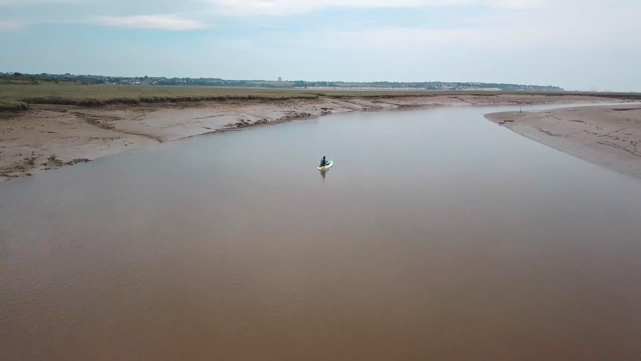구불구불한 강에서 카약을 타는 남자, 배경에 아름다운 풍경을 드러내기 위해 드론 팬