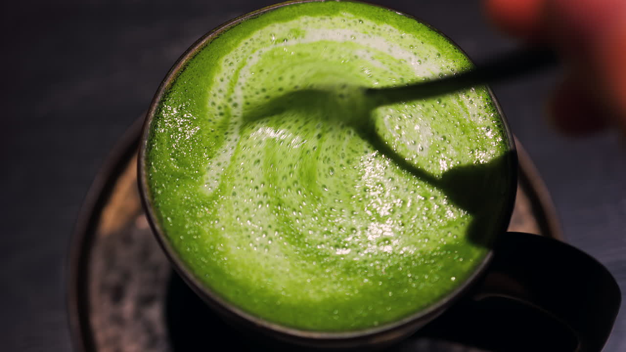 Close up of brown sugar being mixed into a matcha latte on a tray at a cafe