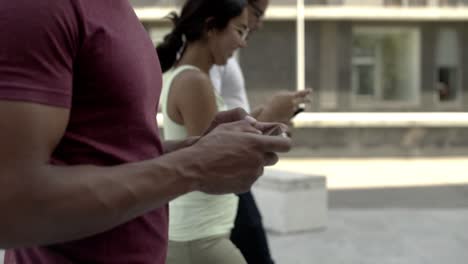 una foto en primer plano de un joven deportivo usando un teléfono inteligente.