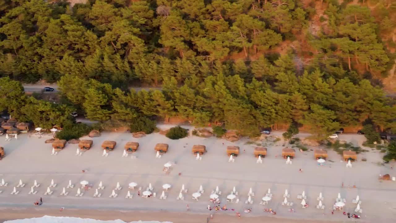 Aerial view of rental cars driving along a road next to a beautiful beach in Turkey