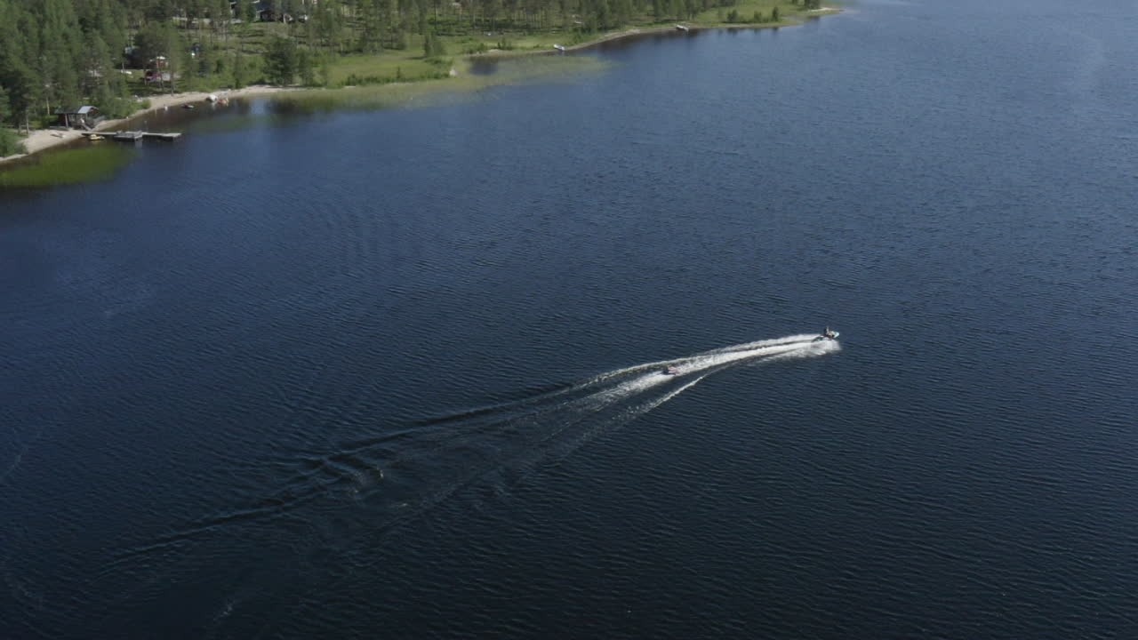 вид с воздуха на двух молодых людей, наслаждающихся жизнью во время катания на гидроцикле в швеции