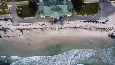 Vista-Aérea-Vertical-Descendiendo-Sobre-La-Playa-Más-Famosa-De-Perth,-Cotesloe,-Australia-Occidental