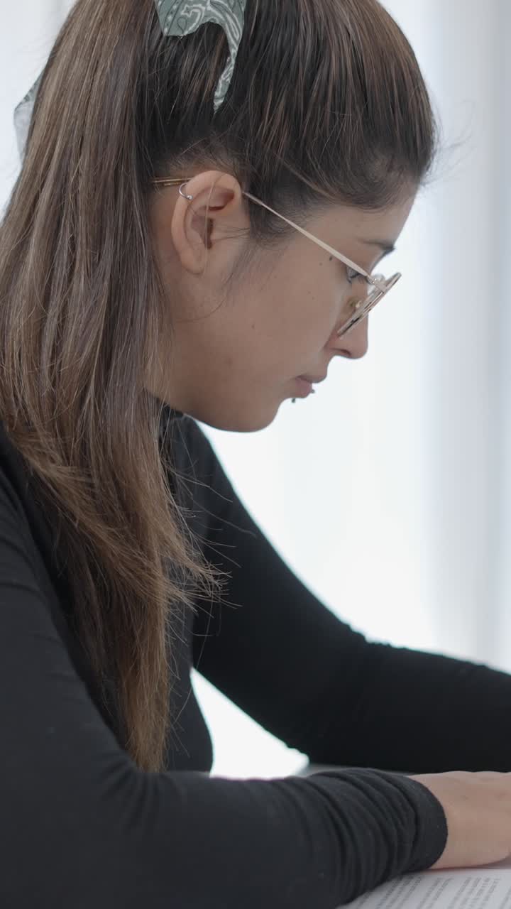 Donna che studia o lavora con gli occhiali