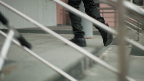 young boy in jacket and backpack standing with calm expression looking around before running toward classroom, blurred background with decorative iron fence and residential buildings