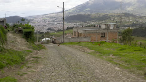 cobblestone road leading uphill towards a town in a mountainous landscape