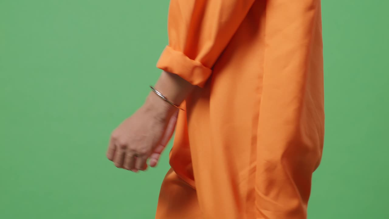 녹색 스크린 배경에서 는 동안 수갑에 인 남성 죄수의 손을 가까이 보십시오.