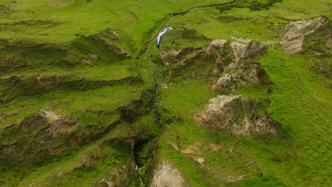 aerial view of paragliding over green hills and valley