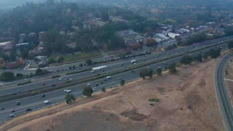 tráfico pesado en la carretera cerca de colinas y humo de incendios forestales