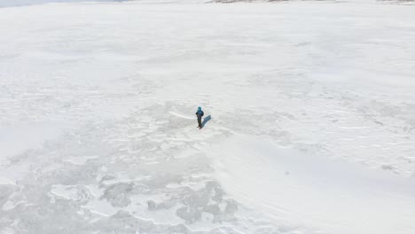 aerial cinematic view male person stands in middle white snow field thoughtful admiring nature. concept of well being and creative process