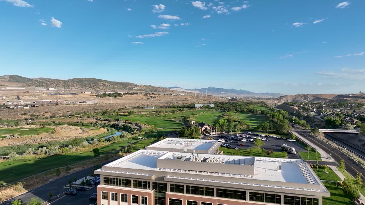 Lehi, Utah business office, LDS church, and Thanksgiving Point club house and golf course on a sunny, summer morning - aerial flyover