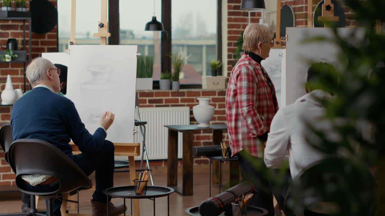 Elder woman helping creative students to develop drawing skills