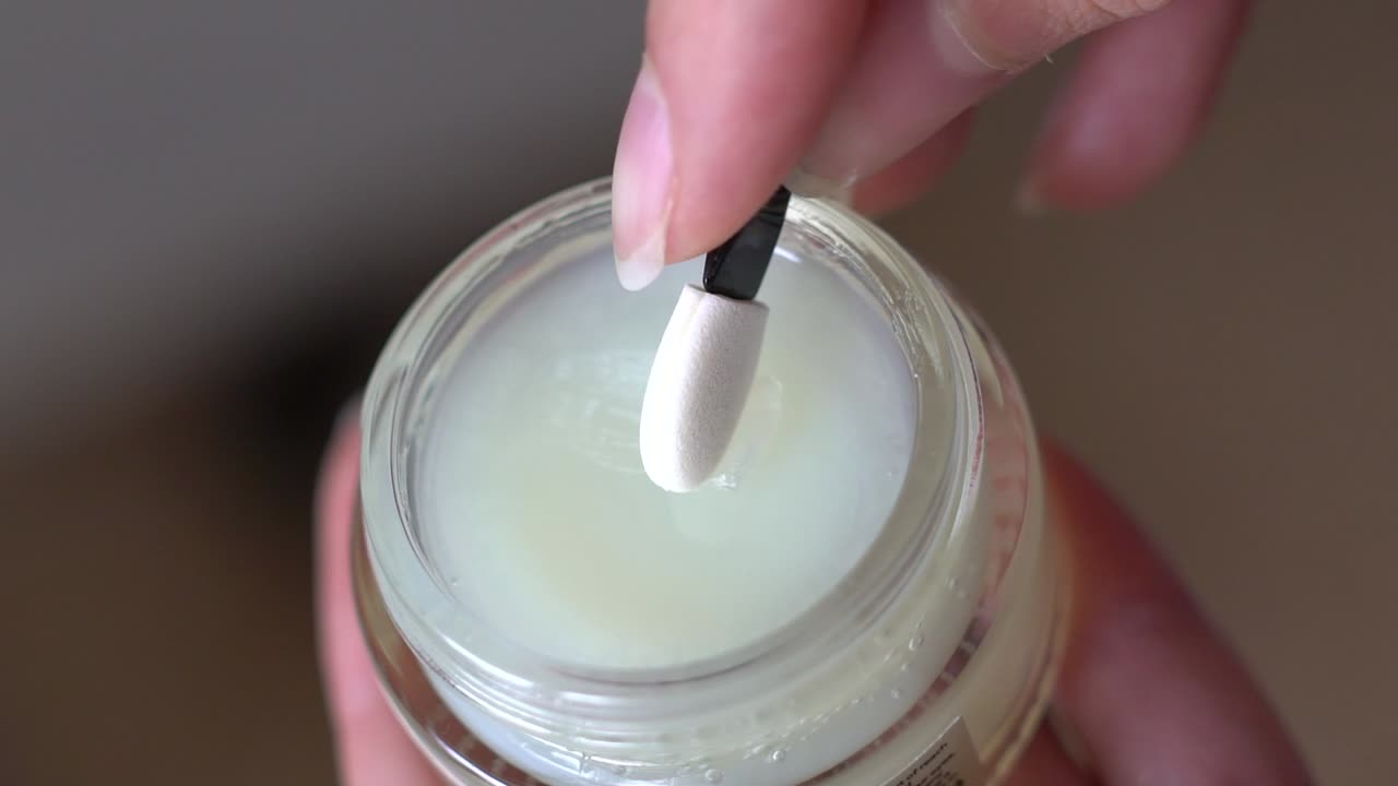 막대기로 항아리에서 위생적인 립스틱을 집으십시오