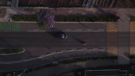 Aerial-top-down-view-people-walk-run-on-sidewalk-by-the-main-road