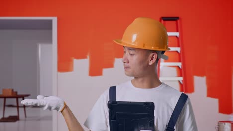 un contratista sonriente con una tableta en una habitación en renovación