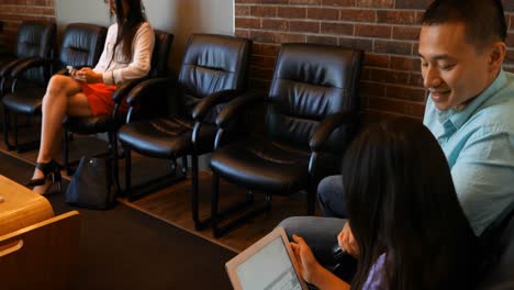 padre e hija usando tableta digital en la clínica dental 4k
