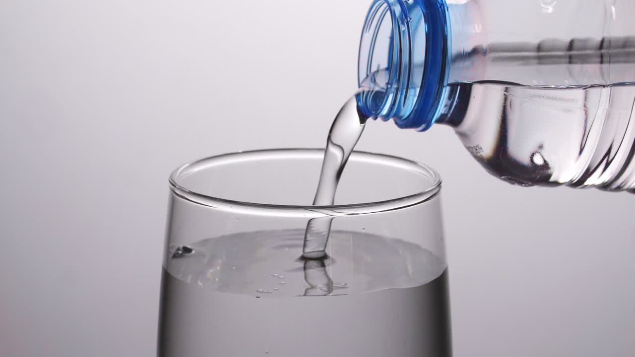 verter agua de la botella en el vaso
