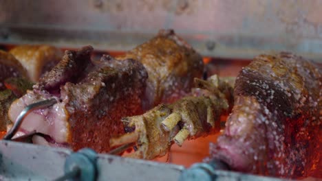 variety of meats being cooked rotisserie style in restaurant oven