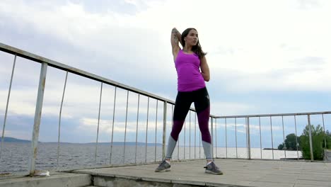 mujer estirándose al aire libre junto al lago