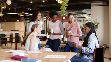 Diverse-businesswomen-having-casual-meeting,-discussing-work-at-office,-in-slow-motion