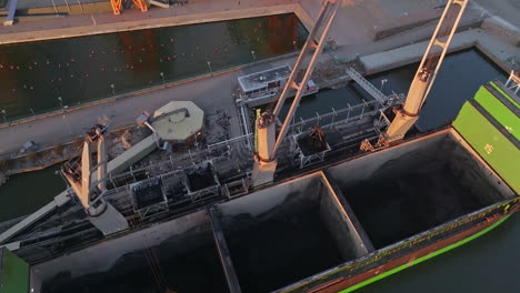 aerial view of a coal ship and cranes at salmisaari harbour, sunset in helsinki