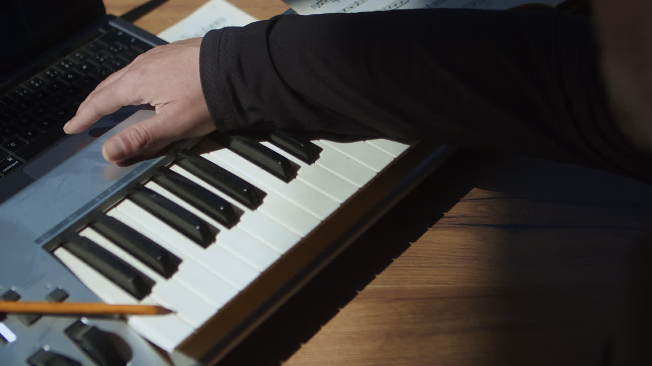 한 사람이 컴퓨터에서 노래를 작곡하고 녹음합니다.