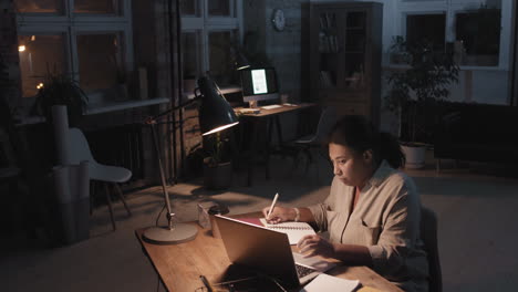mujer trabajando hasta tarde en la noche en su oficina de casa