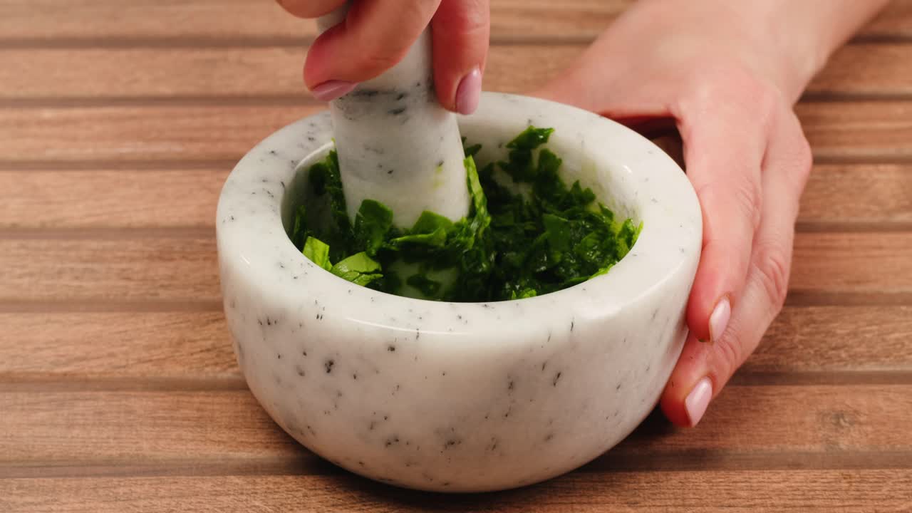 Grinding herbs in a mortar and pestle