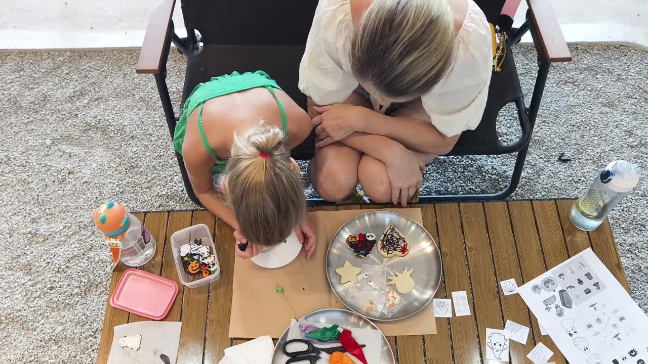 Mamma e figlia che decorano biscotti di Halloween