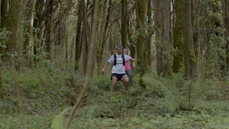 Fit-man-and-woman-running-on-forest-trail
