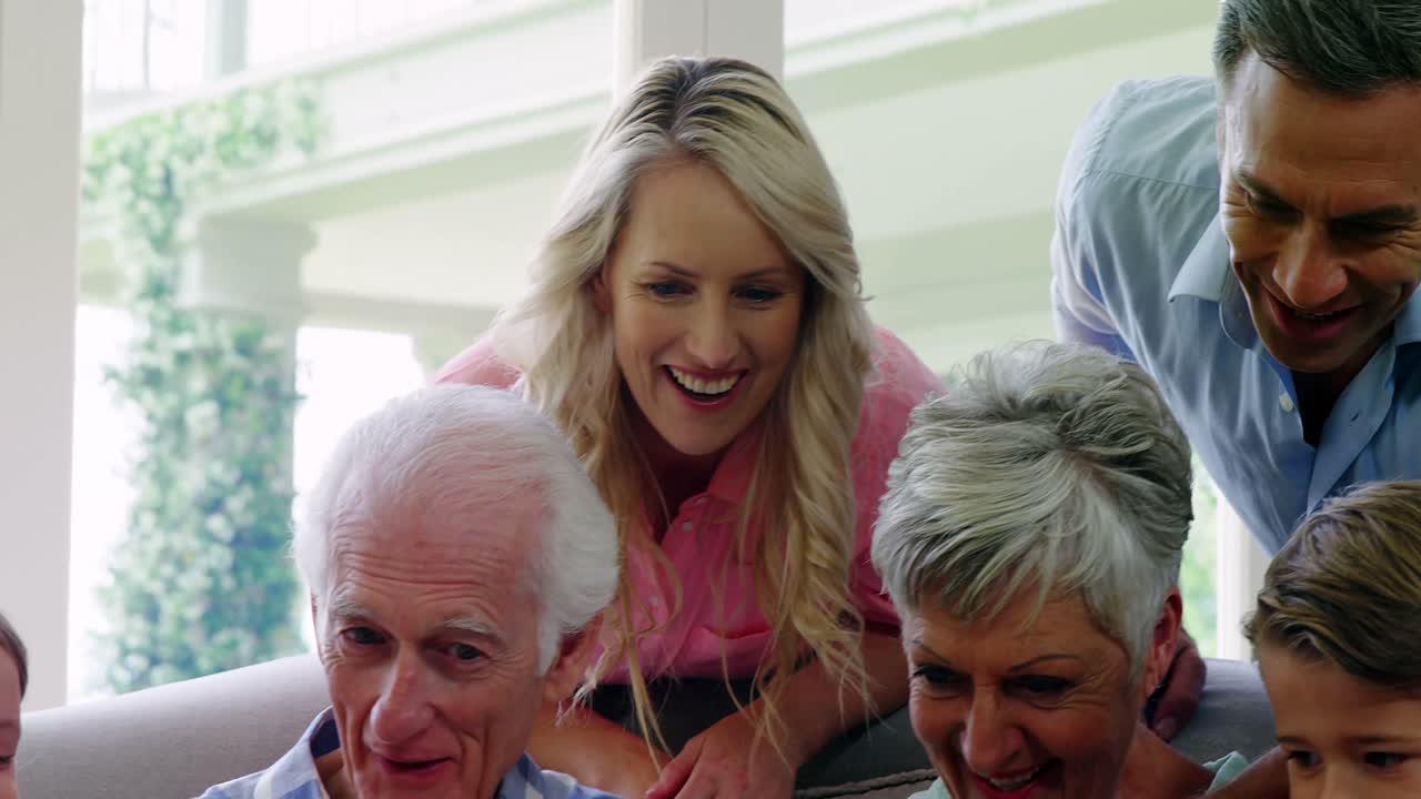 거실에서 노트북을 사용하는 다세대 가족