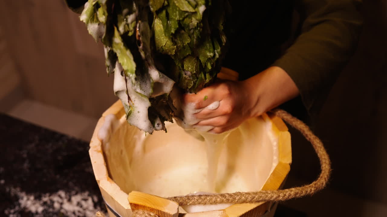 Preparing a traditional Russian bath with birch broom