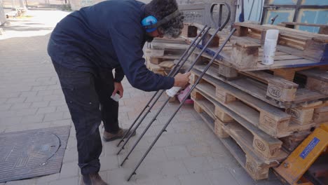 craftsman spraying lacquer on polished iron bars