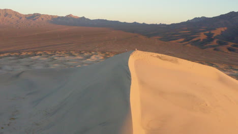 Episches-Reisevideo-Von-2-Personen,-Die-Auf-Einer-Sanddüne-Stehen,-Mit-Einem-Drohnen-Luftvideo